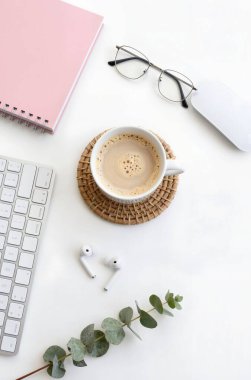 dizüstü bilgisayar ve defter beyaz masada..