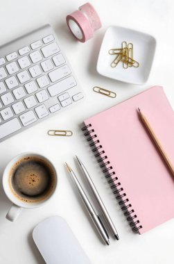 Boş not defteri, dizüstü bilgisayarı ve kahve fincanı olan ofis masası.