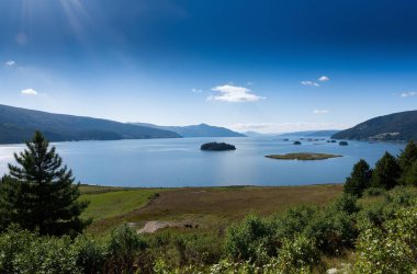 Dağları ve mavi gökyüzü olan güzel bir manzara.