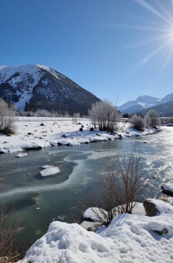 Dağlarda kar ve ağaçlarla kaplı kış manzarası