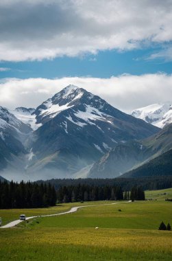 Dağları ve mavi gökyüzü olan güzel bir manzara.