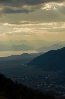 Dağları ve bulutlu gökyüzü olan güzel bir manzara.