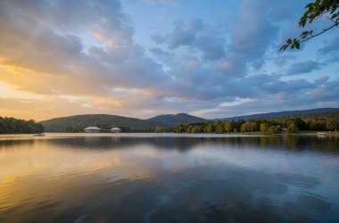 Gölde gün batımı Yazın sudaki ağaçların yansımasıyla