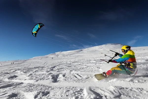 Сноубордист с воздушным змеем едет очень быстро — стоковое фото