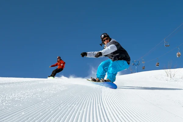 Due snowboarder in sella alla pista da sci — Foto Stock