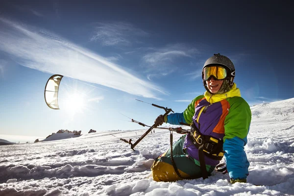 Snowboarder con cometa se sienta en la nieve — Foto de Stock