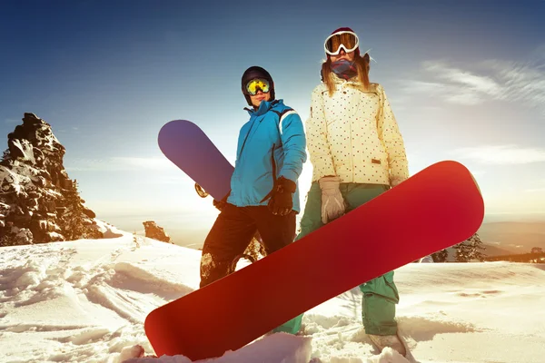 Pareja de snowboarders se para al atardecer — Foto de Stock
