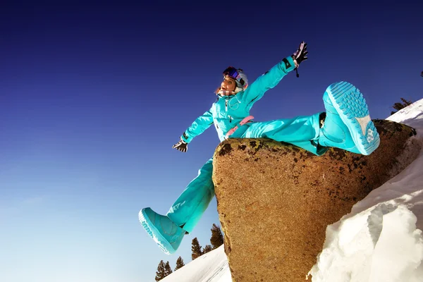 Meisje snowboarder zittend op rots — Stockfoto
