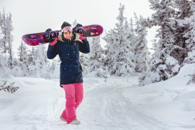 Kız snowboard rüzgârla oluşan kar yığını ile gider