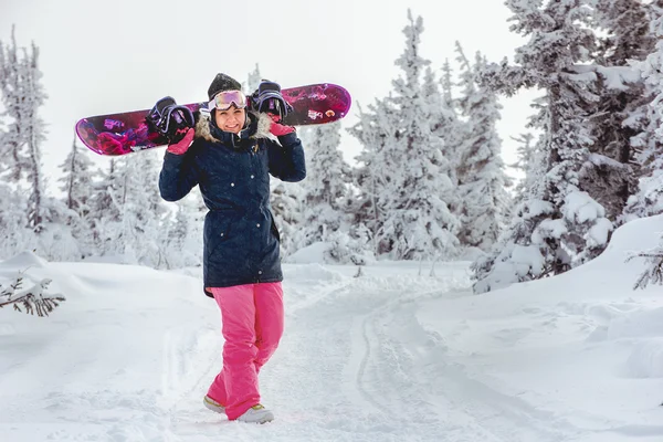 Niña snowboarder va a través de snowdrift — Foto de Stock