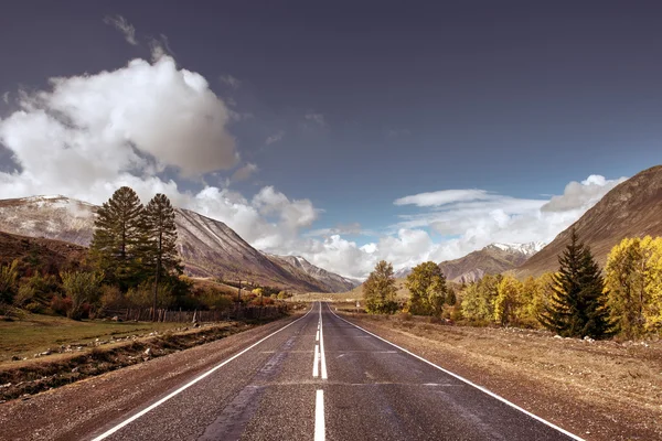 Går raka vägen till horisonten på berg — Stockfoto