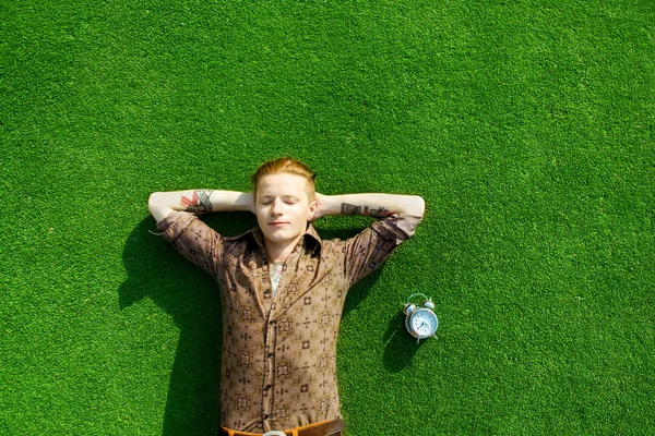 Hipster hombre acostado en verde hierba — Foto de Stock