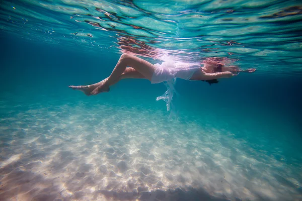 Slim beautiful girl lying on waves — Stock Photo, Image