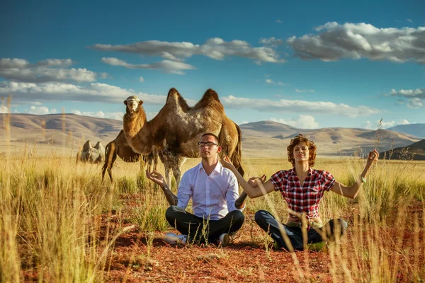 Happy couple sits in lotus position — Stock Photo, Image