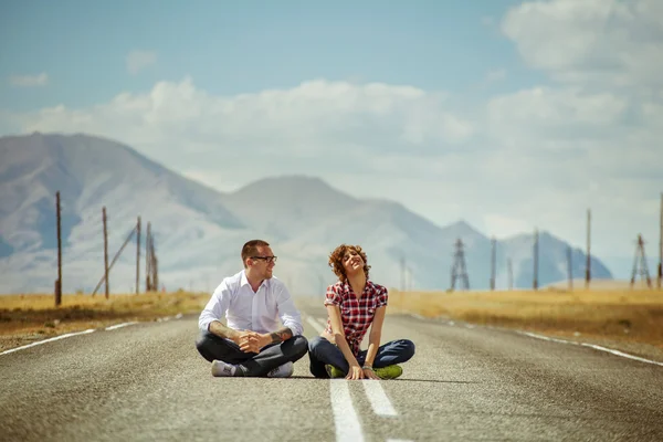 Casal senta-se na estrada — Fotografia de Stock