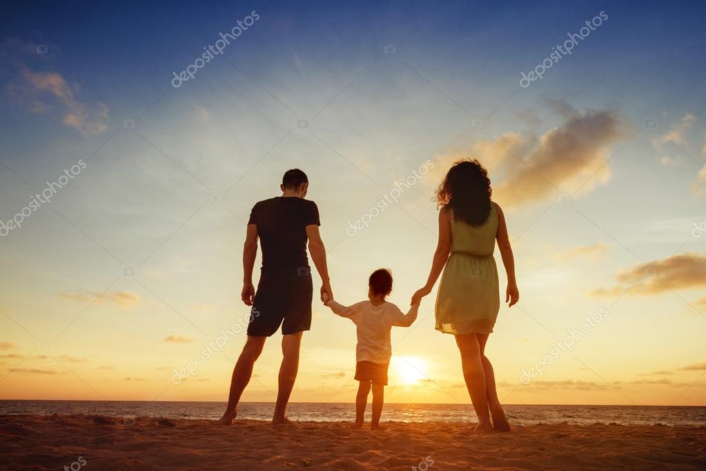 Family standing on sunset