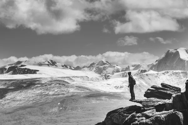 Der Mensch steht auf der Klippe. Hintergrund Berge — Stockfoto