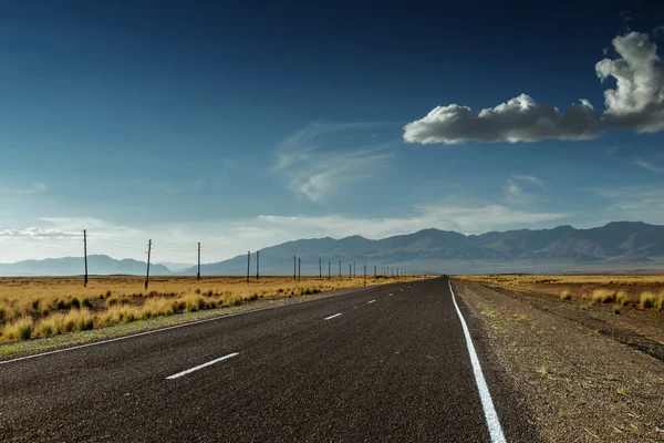 Estrada reta vai para o horizonte e moutains — Fotografia de Stock