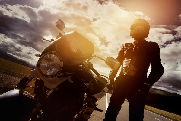 Motociclista fica na estrada com moto — Fotografia de Stock