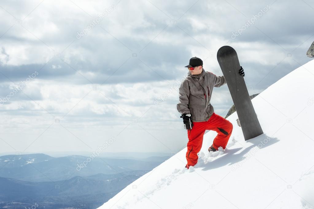 Man snowboarder stands on the slope