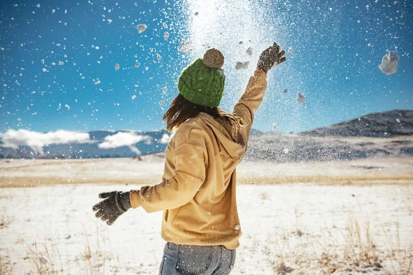 Glückliches Mädchen wirft Schnee und hat Spaß — Stockfoto