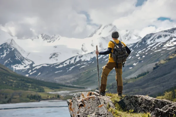 Voyageur avec sac à dos se tient sur grand rocher contre glacier — Photo