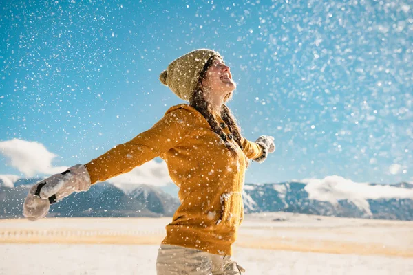 Young happy girl whirls and enjoys snow in mountains — Stock Photo, Image