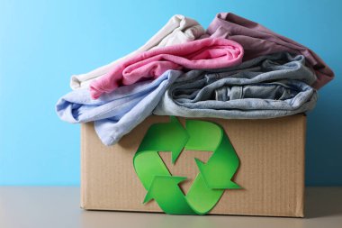 Renkli bir kıyafet yığını, tekstil geri dönüşümünün önemini ön plana çıkarıyor ve çevreye dost unsurlar sunuyor.