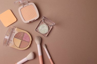Kahverengi Yüzeyde Üst Görünüm Kozmetik Flatlay Kompakt Tozu, Dörtlü Göz farı, Pastel Saplı Fırçalar
