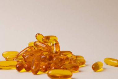 Beyaz Arkaplan Üstündeki Altın Omega Kapsülleri Merkezi Fotokopi Alanı 'nın etrafına yerleştirildi, Parlak Şeffaf Yumuşaklar