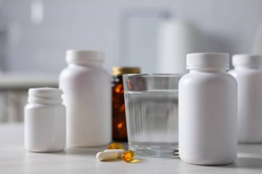 Tezgahın üzerine yerleştirilmiş destek şişeleri, Matte White Plastik Kavanozları arasında ortalanmış Amber Cam Şişe, Yumuşak