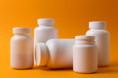 Tarafsız Arkaplan, Çeşitli Tabletler ve Amber Softgels 'e Beyaz Ek Şişeler ve Dağılmış Kapsüller,