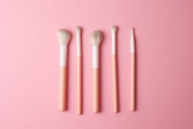 Üst Görünüm Makyaj Fırçaları Işık Arkaplanda, Yumuşak Pembe Kollar ve Minimalist Sıralı Doğal Tüyler
