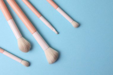 Üst Görünüm Makyaj Fırçaları Işık Arkaplanda, Yumuşak Pembe Kollar ve Minimalist Sıralı Doğal Tüyler