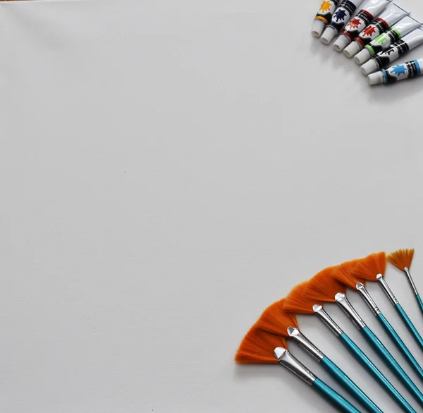 Boya fırçaları ve beyaz tuval üzerine akrilik renkler 