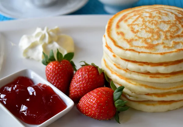 Pancakes served with strawberry and whipped cream Stock Picture