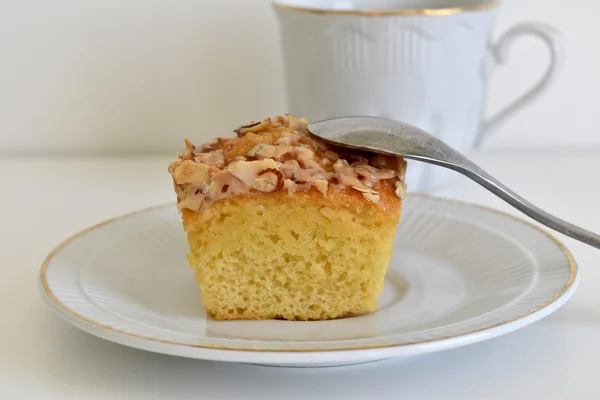 Delicioso bolo de esponja coberto com caramelo crocante e amêndoa — Fotografia de Stock