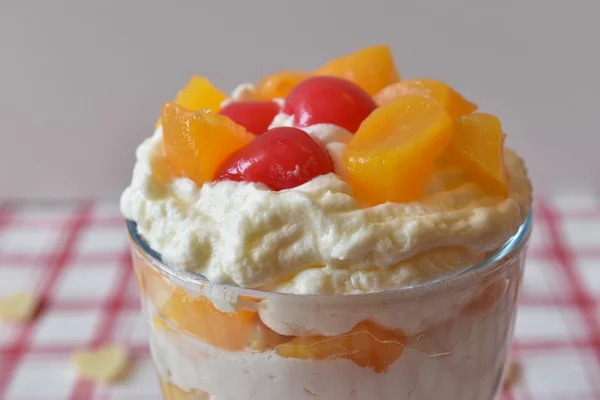 Bicchiere di mousse di vaniglia dolce con frutta in cima — Foto Stock