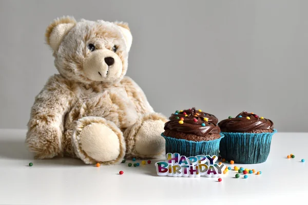 Homemade chocolate cupcake with sprinkles on wooden table mini bear for birthday.