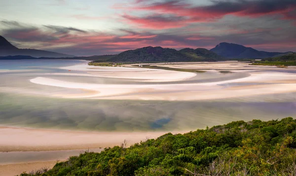 Pembe bulutlar güneş doğarken WhitSunday Adası 'ndaki Hill körfezi üzerinde nadir yeşil renkli.