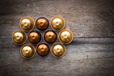 Ahşap arka plan üzerinde Nespresso kapsül.