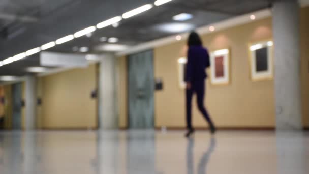 Una mujer en vestido negro caminando en el edificio con vista de perspectiva y editar fuera de foco . — Vídeos de Stock