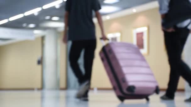 People walking with luggage in building with out of focus. — Stock Video