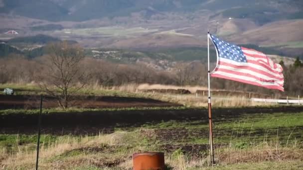 Drapeau des États-Unis agitant dans la journée venteuse avec fond de montagne . — Video