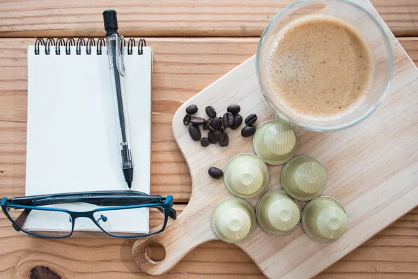 Кофе эспрессо и капсула эспрессо на деревянном столе . — стоковое фото