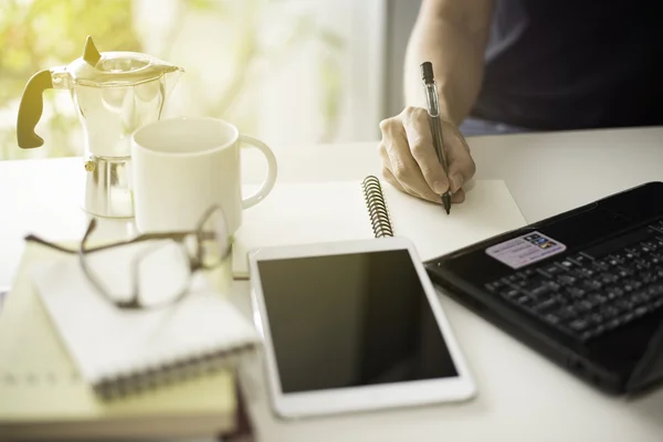 Akıllı telefon ve dizüstü bilgisayar ile parlama ışık efekti kullanarak evden çalışan genç adam.