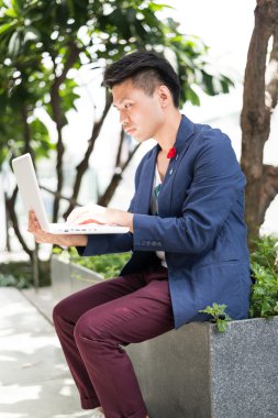 Dizüstü bilgisayar ile Yüzme havuzunda çalışan iş adamı.