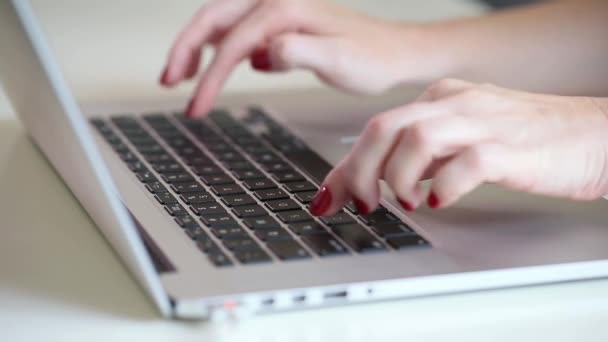 Primo piano sulle mani femminili con smalto rosso che lavora su un computer portatile, concetto di lavoro da casa. Mani a fuoco. — Video Stock