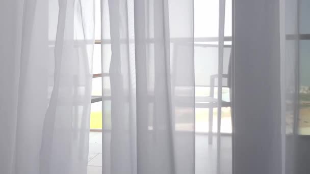 Luz brisa pura cortina que sopla en el viento mirando hacia el balcón detrás de ella, sillas y mesa — Vídeo de stock