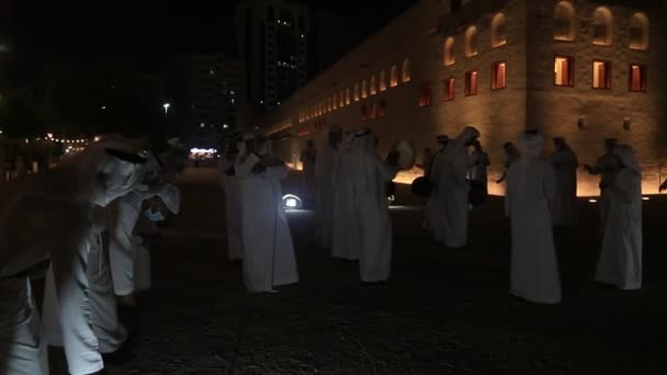 ABU DHABI, Zjednoczone Emiraty Arabskie - MAJ 15, 2021: Tradycyjny męski taniec Emiratów Arabskich Al Ayala w Qasr Al Hosn w nocy świętujący Eid Holidays — Wideo stockowe